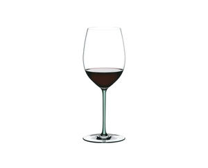 A RIEDEL Fatto A Mano Cabernet/Merlot glass in mint filled with red wine on a transparent background. 