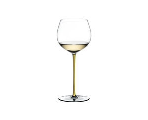 A RIEDEL Fatto A Mano Oaked Chardonnay glass in yellow filled with white wine on a transparent background. 