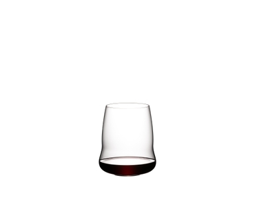 Two SL RIEDEL Stemless Wings Cabernet/Merlot glasses on a white background. The SL RIEDEL Stemless Wings Cabernet/Merlot glass on the left side is filled with red wine, the other one is unfilled. 