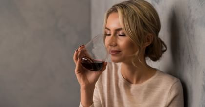a woman with a Riedel SL Winewings glass filled with red wine