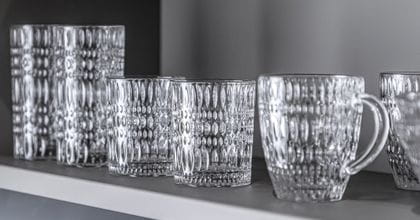 NACHTMANN Ethno crystal longdrink glasses, tumblers and the hot beverage mug in a row on a shelf.<br/>