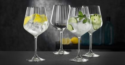 Four NACHTMANN Gin and Tonic glasses, three of them filled with different gin cocktails, one of them empty.