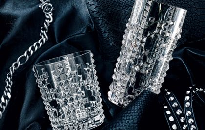 Il bicchiere da whisky NACHTMANN Punk e il bicchiere da longdrink appoggiati su una giacca di pelle con rivetti e una catena.<br/>
