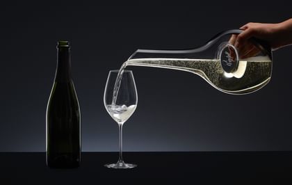 Champagne is poured from a decanter into a champagne glass