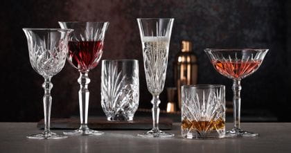 The NACHTMANN series Palais with the white wine goblet next to the filled red wine goblet, the filled taper Champagne glass, the filled whisky tumbler, the filled cocktail glass and the fruit juice tumbler.<br/>