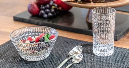 The NACHTMANN Ethno bowl filled with cereals and berries on a table mat. Next to it are two spoons, in the background is a bowl with fruits.<br/>