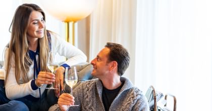couple holding RIEDEL glasses smiling at one another