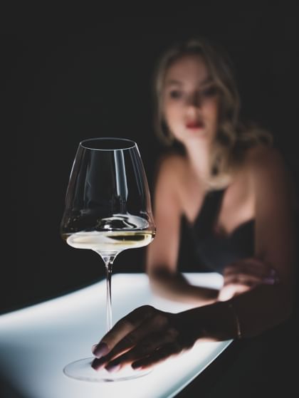 a woman with a Riedel Winewings glass in her hands