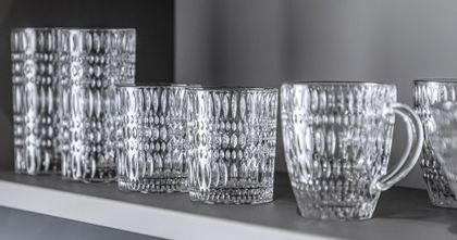 Vasos largos de cristal NACHTMANN, vasos y la taza para bebidas calientes en fila sobre una estantería.<br/>