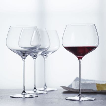 Four SPIEGELAU Willsberger Anniversary Burgundy glasses, one of them filled with red wine.<br/>
