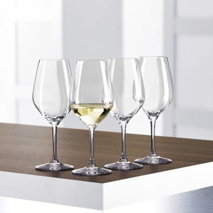 Cuatro copas de vino blanco SPIEGELAU Authentis de tamaño pequeño sobre una mesa, una de ellas llena de vino blanco.<br/>