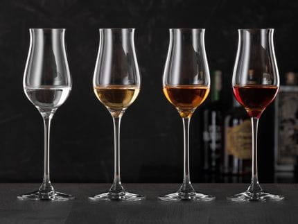 Four SPIEGELAU Digestive glasses, filled with different spirits.<br/>