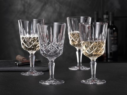 The Nachtmann Noblesse Cocktail/Wine Goblet filled with white wine on a black table with a black background.