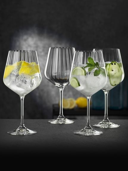 Four NACHTMANN Gin and Tonic glasses, three of them filled with different gin cocktails, one of them empty.<br/>