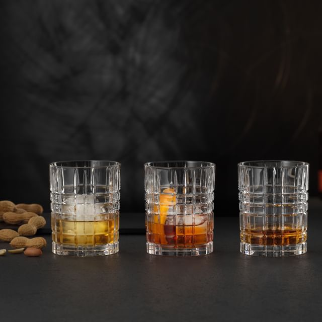 Quattro tumbler quadrati da whisky NACHTMANN riempiti con diverse bevande alcoliche e analcoliche.<br/>