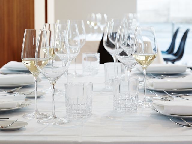 A laid table with SPIEGELAU Superiore Bordeaux glasses and filled white wine glasses at each of the six places. In the middle of the table there are four tumblers of the SPIEGELAU Perfect Serve Collection.<br/>