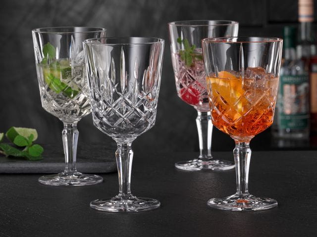 Vier NACHTMANN Noblesse-Cocktailgläser, drei davon gefüllt mit verschiedenen Spritz-Cocktails, eines ist leer.<br/>