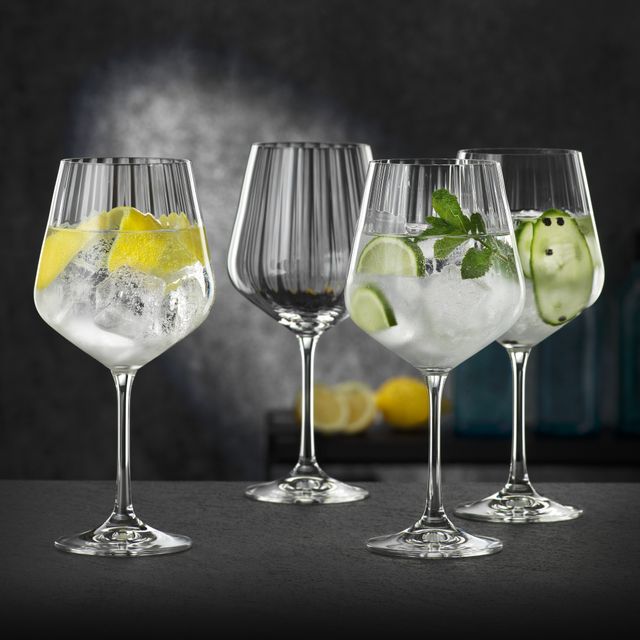 Four NACHTMANN Gin and Tonic glasses, three of them filled with different gin cocktails, one of them empty.<br/>